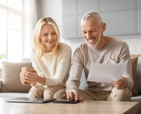Cheerful couple with financial plans at home